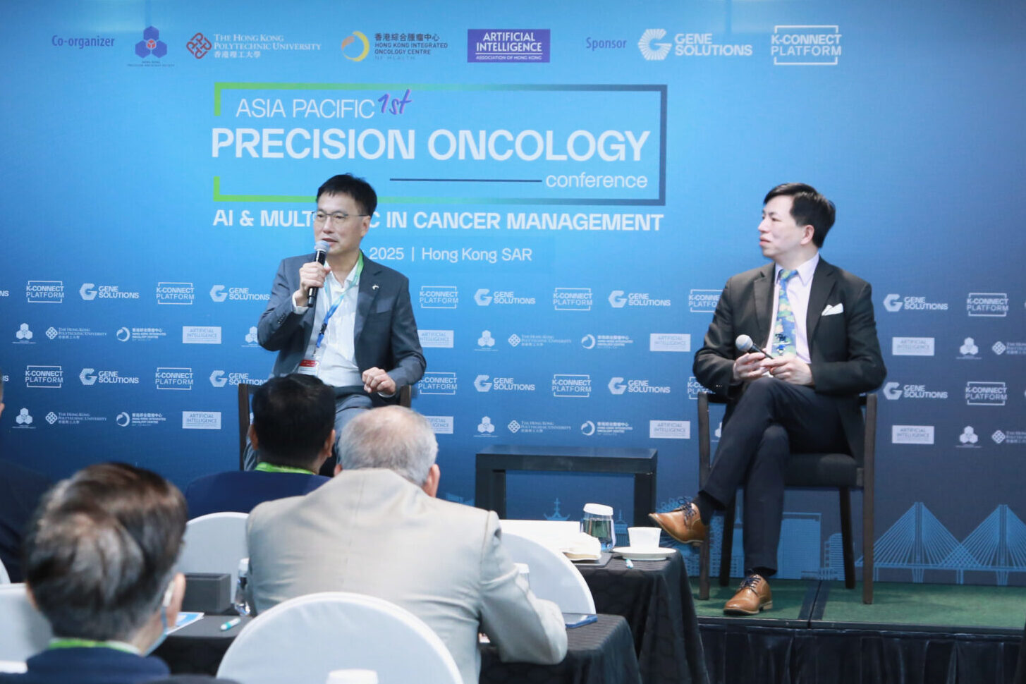 Panel discussion - Session 2 at the APAC Precision Oncology Conference 2025 on operationalizing genomic and transcriptomic insights. From left to right on stage: Dr. Joseph Au (President, Hong Kong Precision Oncology Society) and Dr. William Cho (Queen Elizabeth Hospital), with Prof. Aya Helali (Queen Mary Hospital) joining virtually.